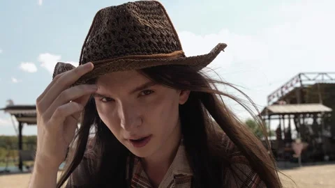 Young handsome guy with straight long hair adjusts his straw wicker hat Stock Footage 264508670