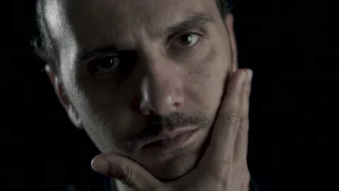 Young handsome guy is touching beard on black background, studio shot. Stock Footage 133883568