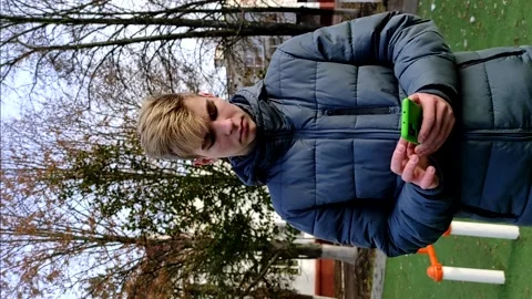 Young handsome guy uses a mobile phone outdoor in autumn. Stock Footage 143813010