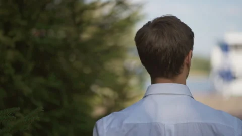 Young handsome happy guy, the groom walks in the park, looks at the sunlight. Stock Footage 126519772