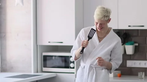 Young handsome happy man having fun in kitchen, listening to music and singing Stock Footage 227458664