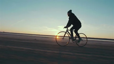 Young handsome hipster man riding fixed gear bicycle during sunset, outdoor Stock Footage