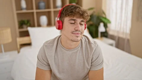 Young, handsome hispanic man relaxing in comfort, joyfully listening to fun.. Video stock 262204895