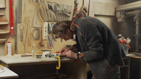 Young handsome joiner make sharping his tool in workshop Stock Footage 155616139