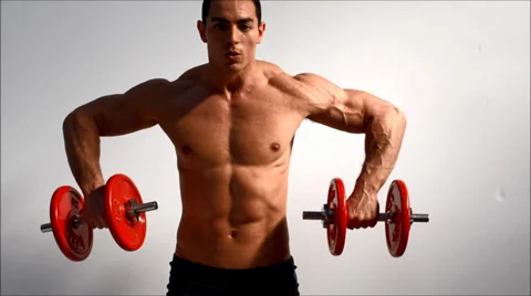 Young handsome male bodybuilder training shoulders with dumbbells Stock Footage 37145160