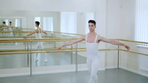 Young handsome male dancer practicing in classical ballet in small studio with Video stock 91382962