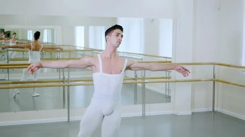 Young handsome male dancer practicing in classical ballet in small studio with Video stock 91383564