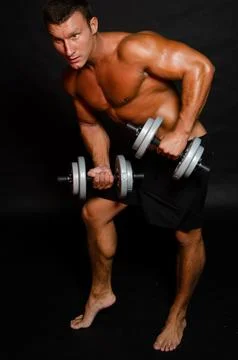 Young handsome man with athletic body posing in the studio. Stock Photos