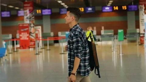 Young handsome man with the baggage walking in the modern airport terminal Stock Footage 79101158