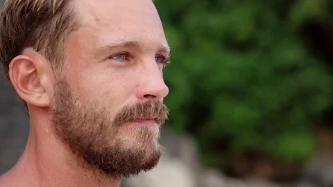 Young handsome man with beard and mustache posing on the beach in Bali Stock Footage 71537104