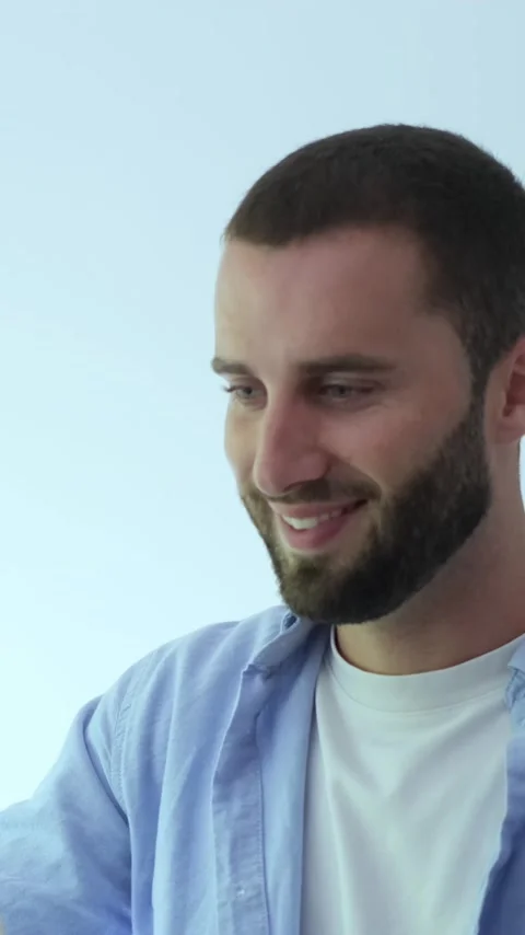 Young handsome man with a beard and blue eyes wearing a casual shirt, looking Vídeos de archivo 345078455