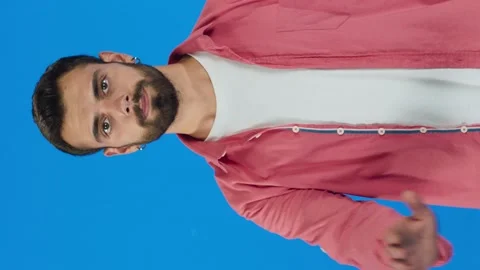 Young handsome man with beard on blue background makes stop sign with palms. Stock Footage 143916805