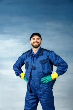 Young handsome man with a beard in a blue working uniform for cleaning Stock Photos