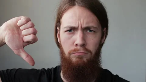 Young handsome man with beard expressing discontent and showing thumb down Stock Footage 169747433
