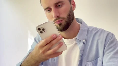 Young handsome man with a beard feeling upset and disappointed while looking at Vídeos de archivo 344756415