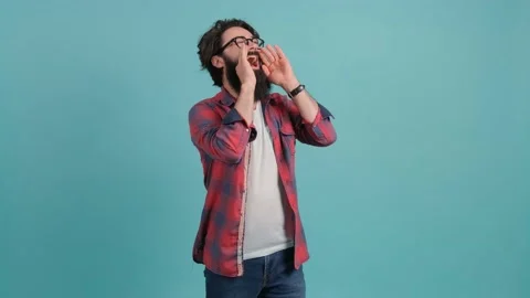Young handsome man with beard shouting angry out loud with hands over mouth. Stock Footage 141679643