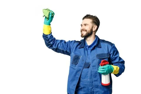 Young handsome man with a beard in the uniform of a cleaner smiles while hold Stock Photos
