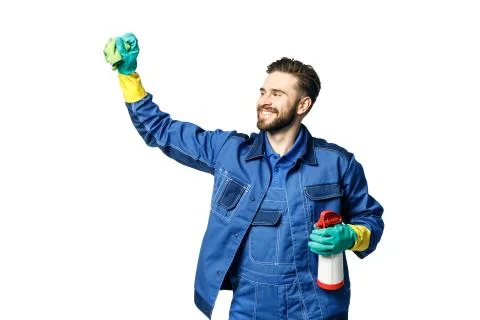 Young handsome man with a beard in the uniform of a cleaner smiles while hold Stock Photos