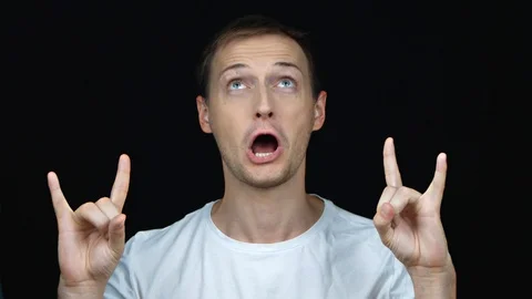 Young handsome man on black background making a rock gesture, enjoying life a Stock-Footage 112395904