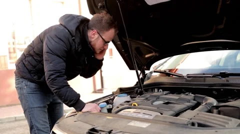 Young, handsome man in black jacket and glasses standing behind his car (4) Stock Footage 49338338