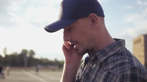 Young handsome man in a cap talking on the phone in the street. HD, 1920x1080 Stock Footage 78157777