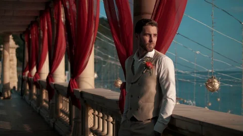 Young handsome man in classic clothes stands in a beautiful location Stock Footage 128598645