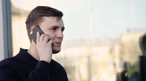 Young handsome man communicating over the telephone in the street Stock Footage 61837898