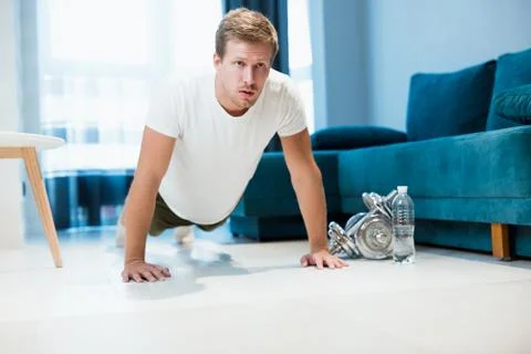 Young handsome man doing pushups during workout at home live sporty Stock Photos