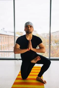 Young handsome man doing yoga meditation indoors Stock Photos