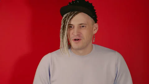 Young handsome man with dreadlocks in black cap talking, looking away, smiling Stock Footage 199316755