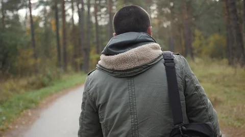 Young handsome man dressed in a jacket walking in a autumn forest. Portrait on Stock Footage 82607211