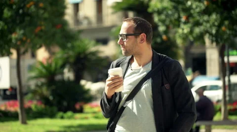 Young, handsome man drinking coffee while standing in city HD Stock Footage 51244023