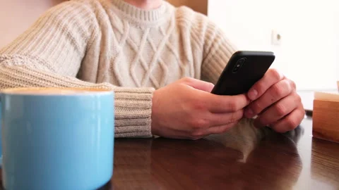 Young, handsome man drinking coffee and using smartphone in cafe. Stock Footage 148571719