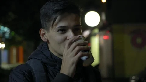 Young handsome man drinks tea on the street at night, 4k 3 Video stock 95725456