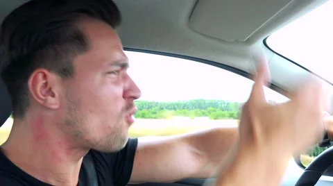 Young handsome man drives a car and scolds behind the wheel Stock Footage