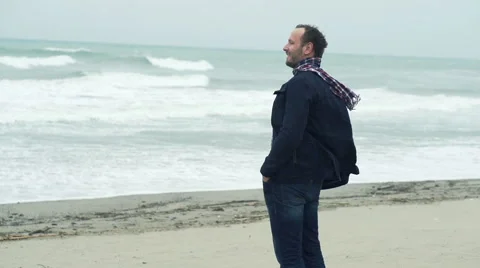 Young handsome man enjoying view of the beach on a stormy day, 240fps Stock Footage 59911166