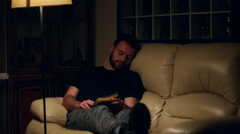 Young handsome man falls asleep while reading book at home Stock Footage 59955463
