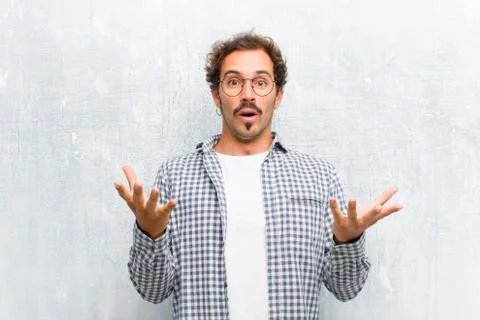 Young handsome man feeling extremely shocked and surprised, anxious and panic Stock Photos