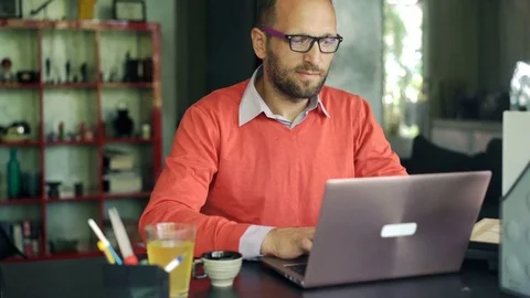 Young handsome man finish work on laptop and drinking tea by table at home 4k Stock Footage 74851454
