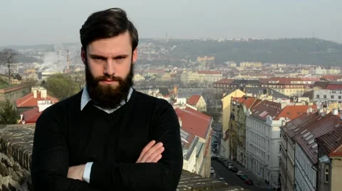 Young handsome man with full-beard (hipster) looks to camera (confident look) 스톡 동영상 49761084