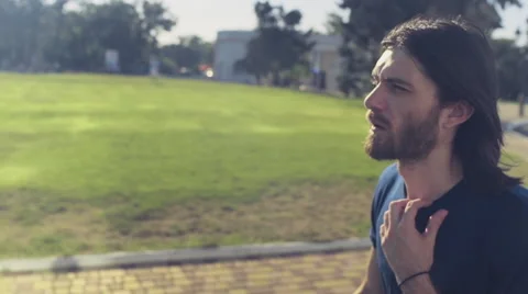Young handsome man goes through the park slow motion Stock Footage 53334243