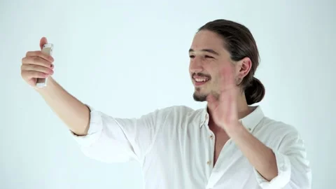 Young handsome man having video chat with friends on smart phone Stock Footage 136007102