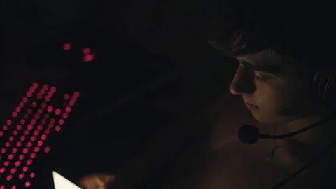 Young handsome man in headset with microphone using smartphone, sitting near Stock Footage 128967925