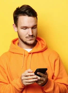 Young handsome man holding mobile phone and making photo of himself while Stock Photos