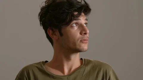 Young handsome man looking around and smiles at camera Stock Footage