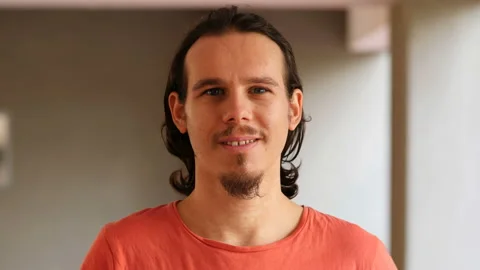 Young handsome man looking at camera and smiling Stock Footage 141678227