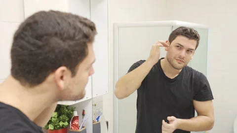 Young handsome man looking at himself in the mirror. Stock-Footage 221645987