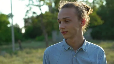 Young handsome man looks at camera at sunset, outdoors, 4k 4 Video stock 95140930