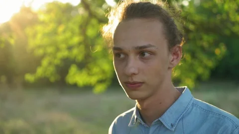 Young handsome man looks at camera at sunset, outdoors, 4k 3 Stock Footage 95140994