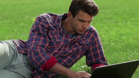 Young handsome man lying on grass 스톡 동영상 252680624